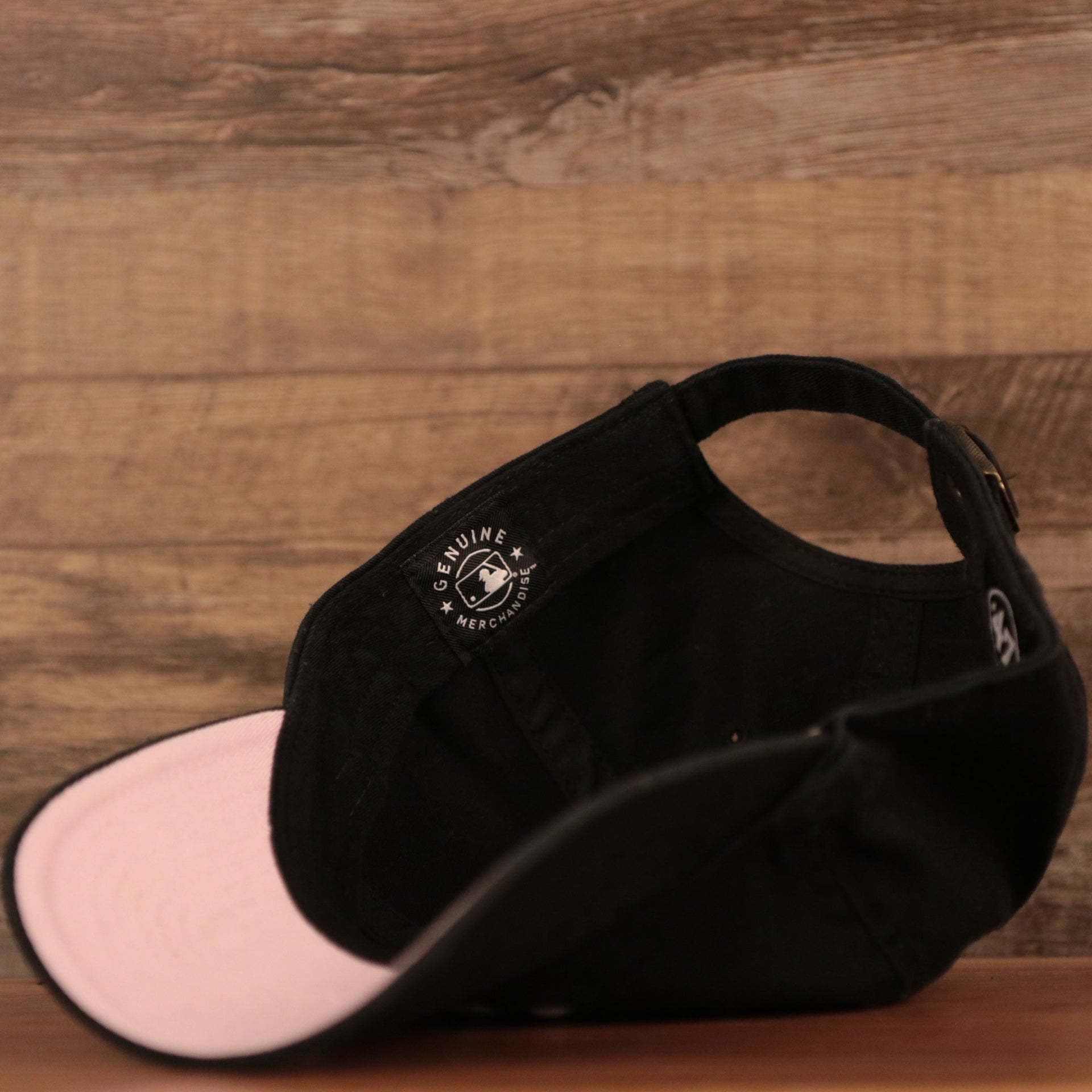 The genuine merchandise of the black Yankees pink bottom adjustable dad hat by 47 Brand.