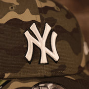 The white New York Yankees logo on the front side of the Yankees 2021 Memorial Day hat.