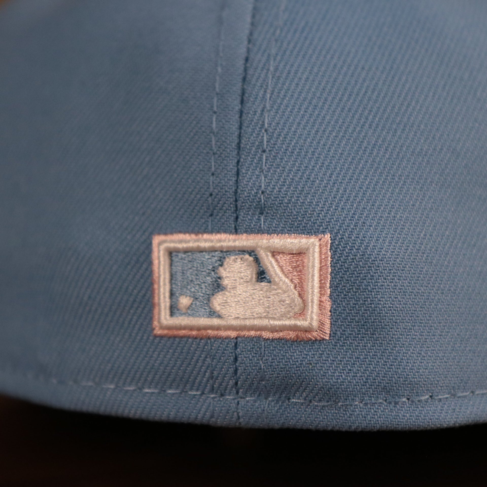 The MLB logo on the back side of the retro Philadelphia Phillies 1996 All Star Game pink underbrim fitted cap.