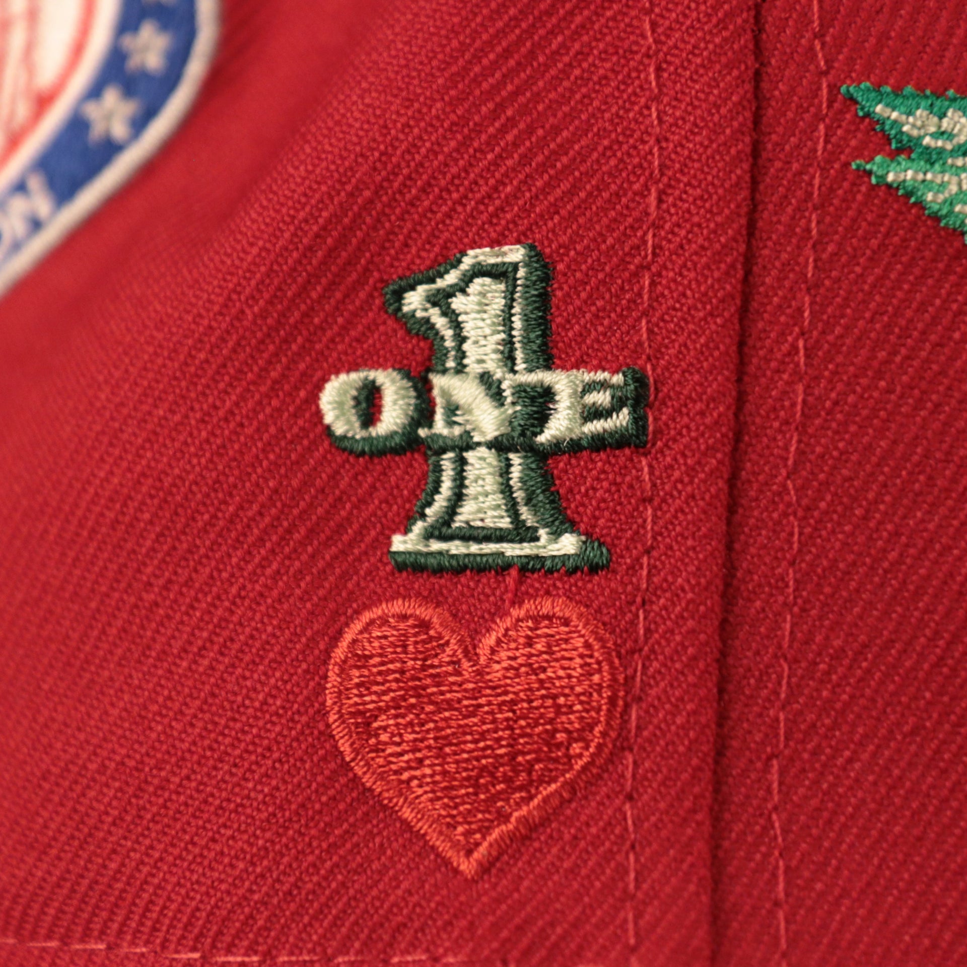 The number 1 patch on the right side of the red all over embroidered Philadelphia Phillies fitted cap.