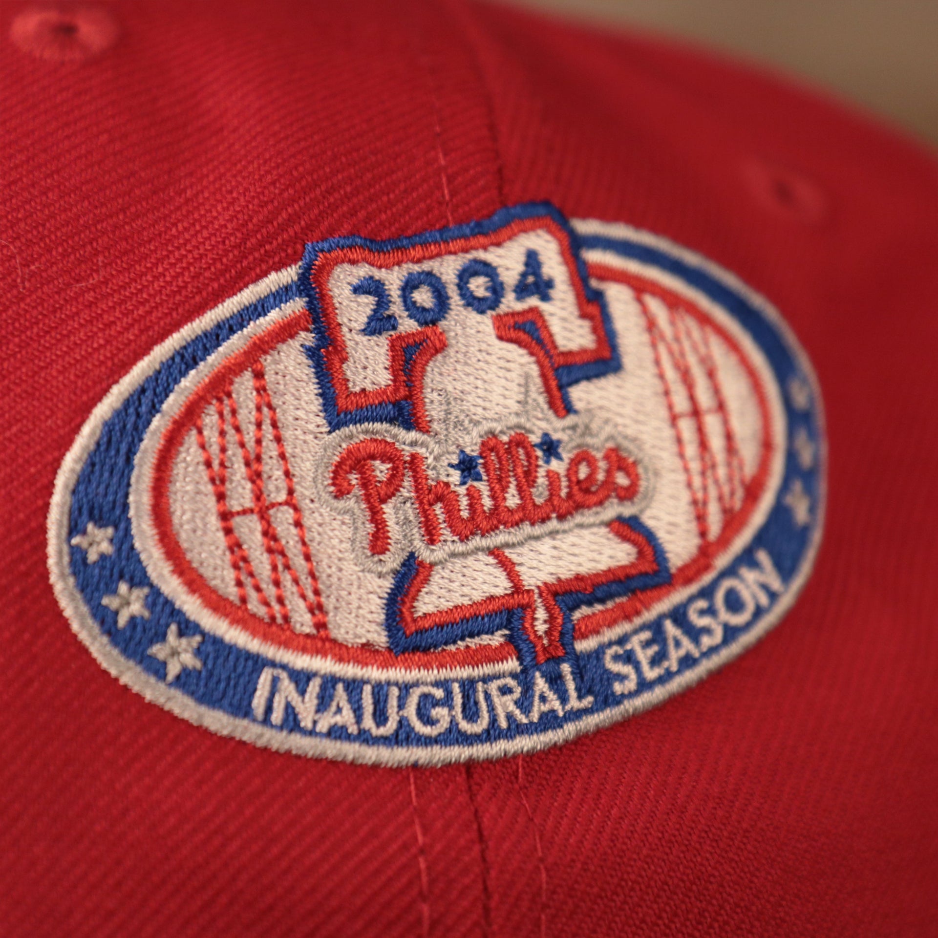 The 2004 inaugral season patch on the red all over fitted hat by New Era.
