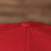 The button of the red Philadelphia Phillies all over embroidered fitted cap with grey underbrim.