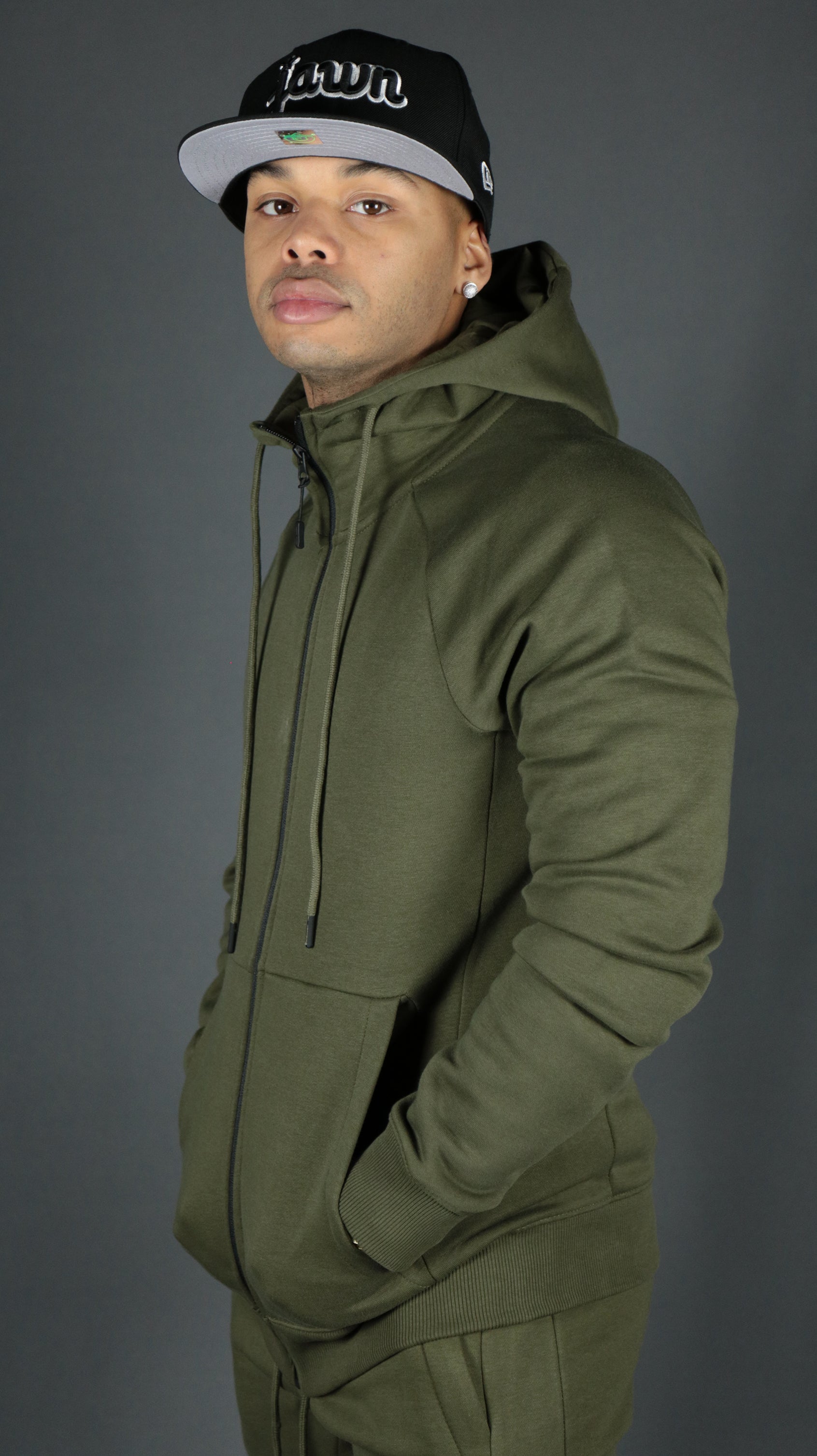 A model wearing the olive military green Jordan Craig basic tech fleece zipup hoodie.