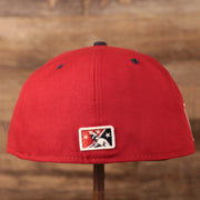 The Minor League Baseball logo on the back side of the red coqui fitted cap.