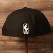 The NBA logo on the back side of the black 17x Los Angeles Lakers champs hat.