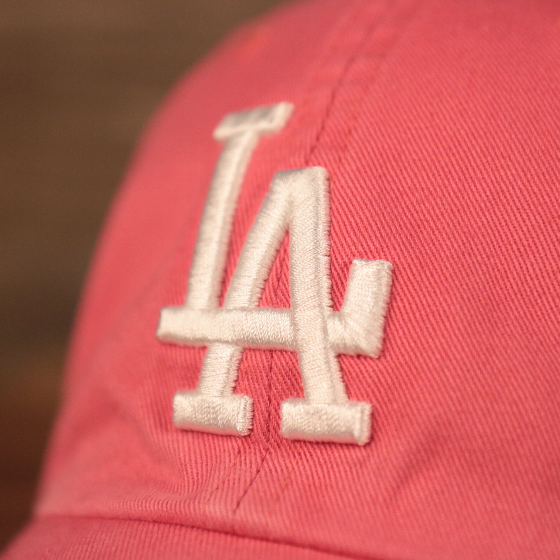 The white Los Angeles Dodgers logo on the front of the green bottom ball cap by 47 Brand.
