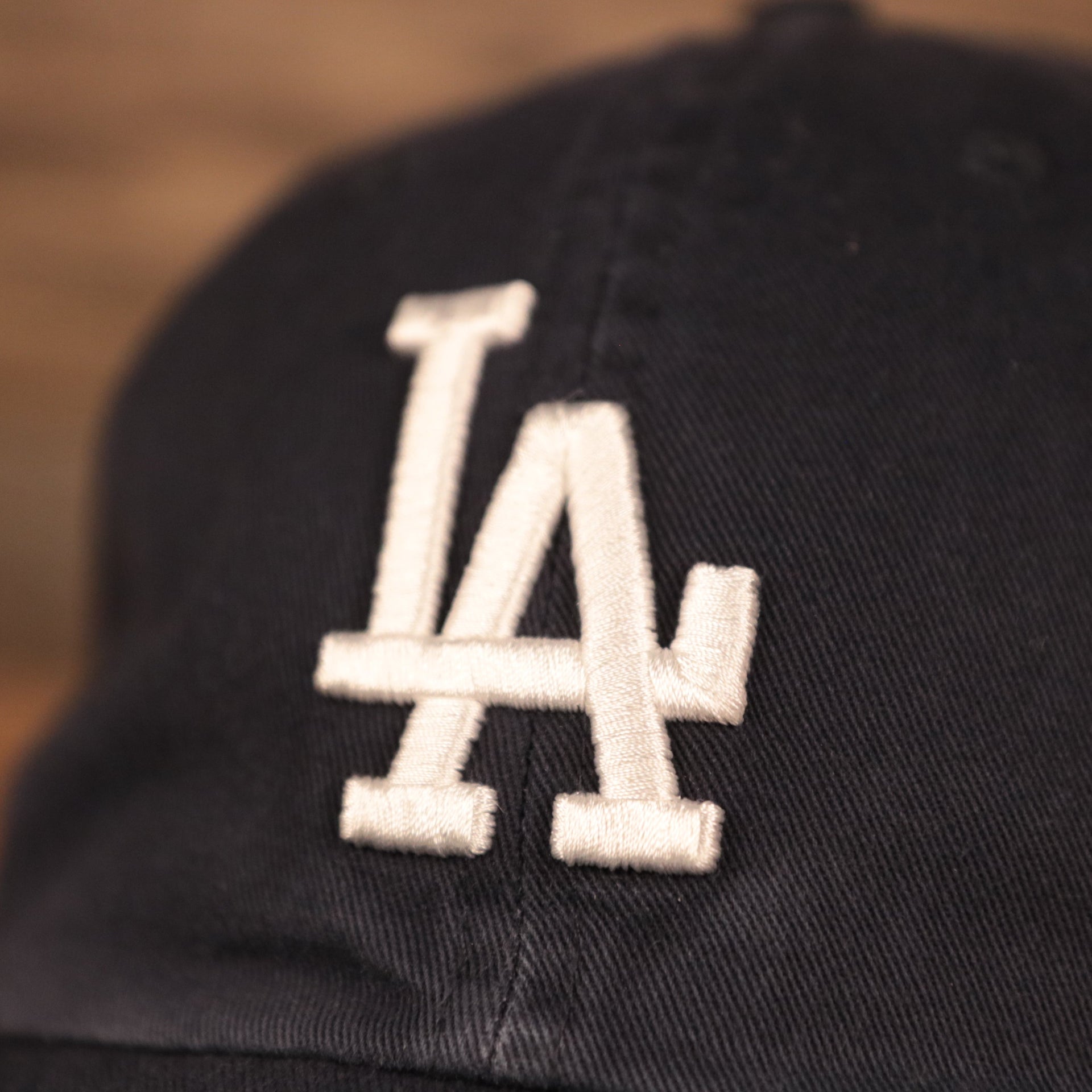 The white Los Angeles Dodgers logo on the front of the pink bottom ball cap by 47 Brand.