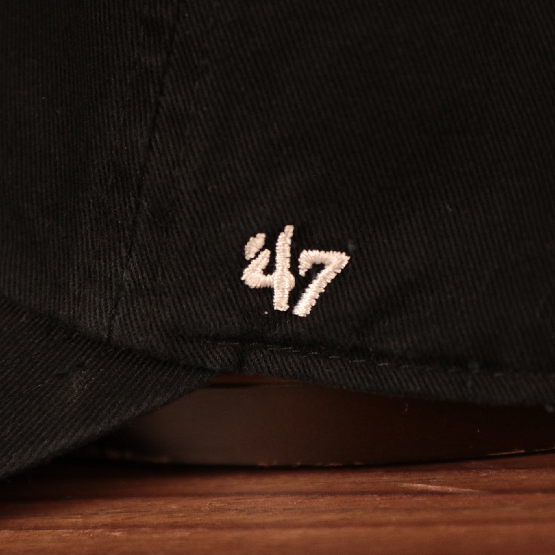 The left side of the black Yankees pink bottom ball cap has the logo of 47 Brand.