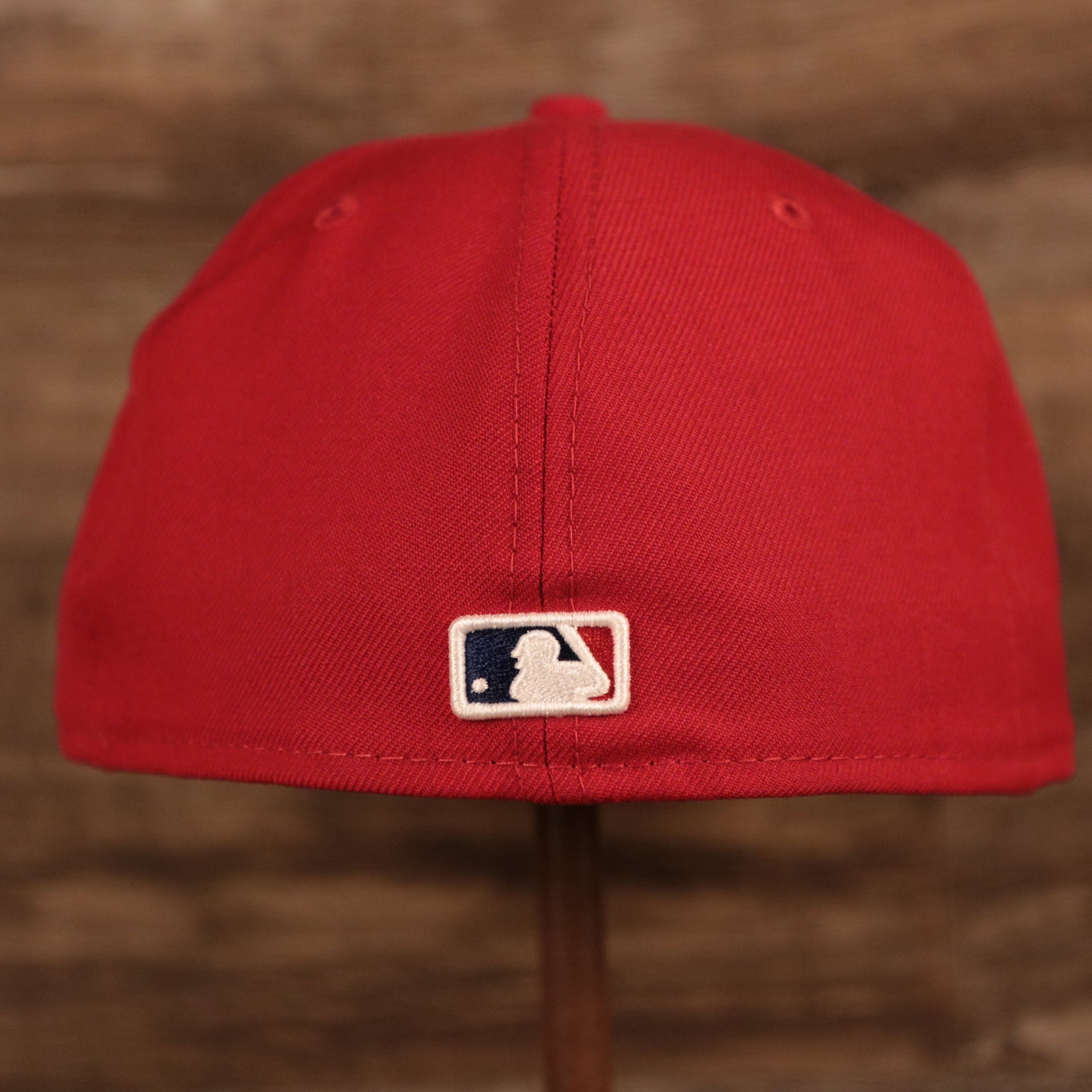 The MLB logo on the back side of the red Philadelphia Phillies Philly Cheesesteak 59fifty grey bottom fitted cap.