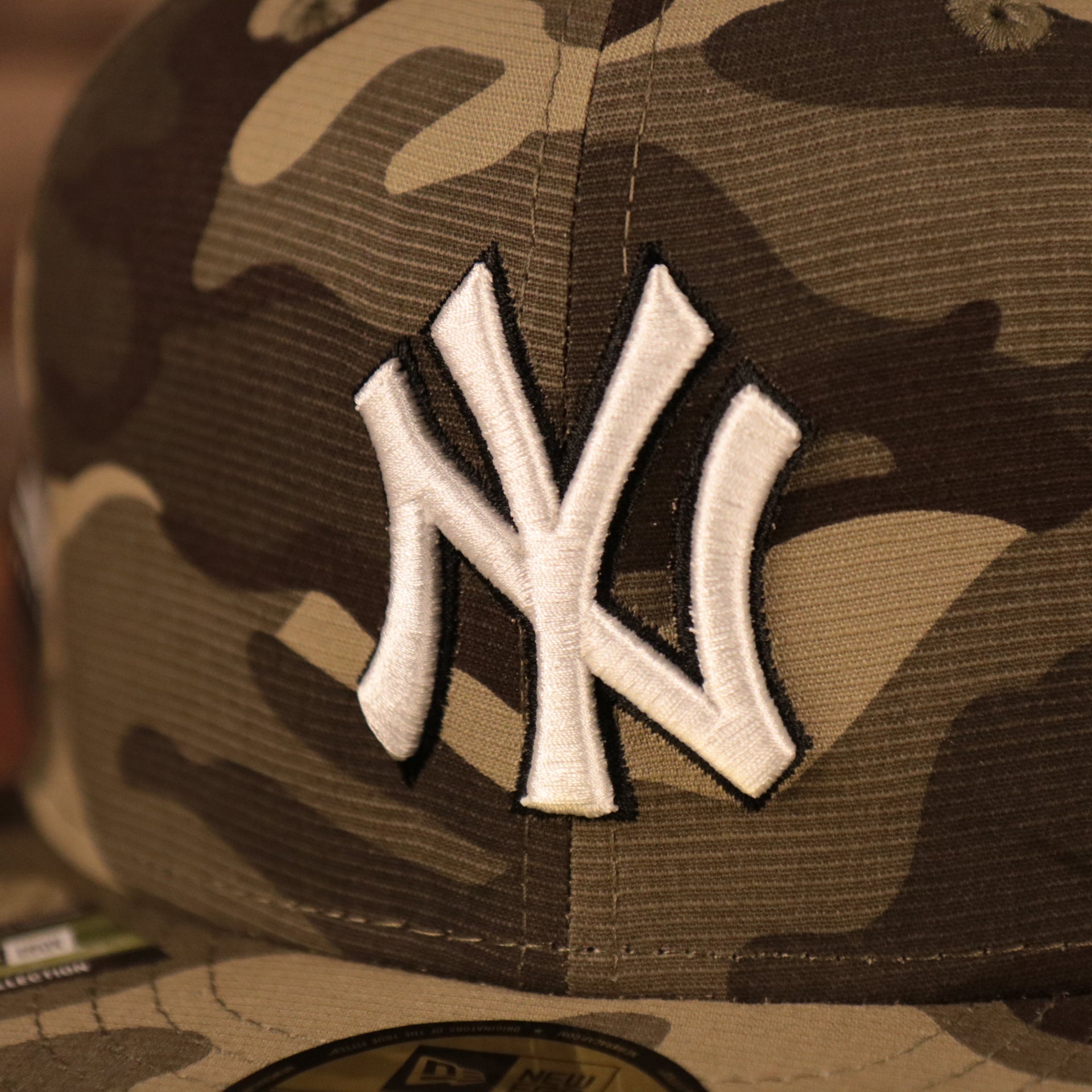The New York Yankees white logo on the front side of the Yankees Armed Forces Day On Field Hat by New Era.