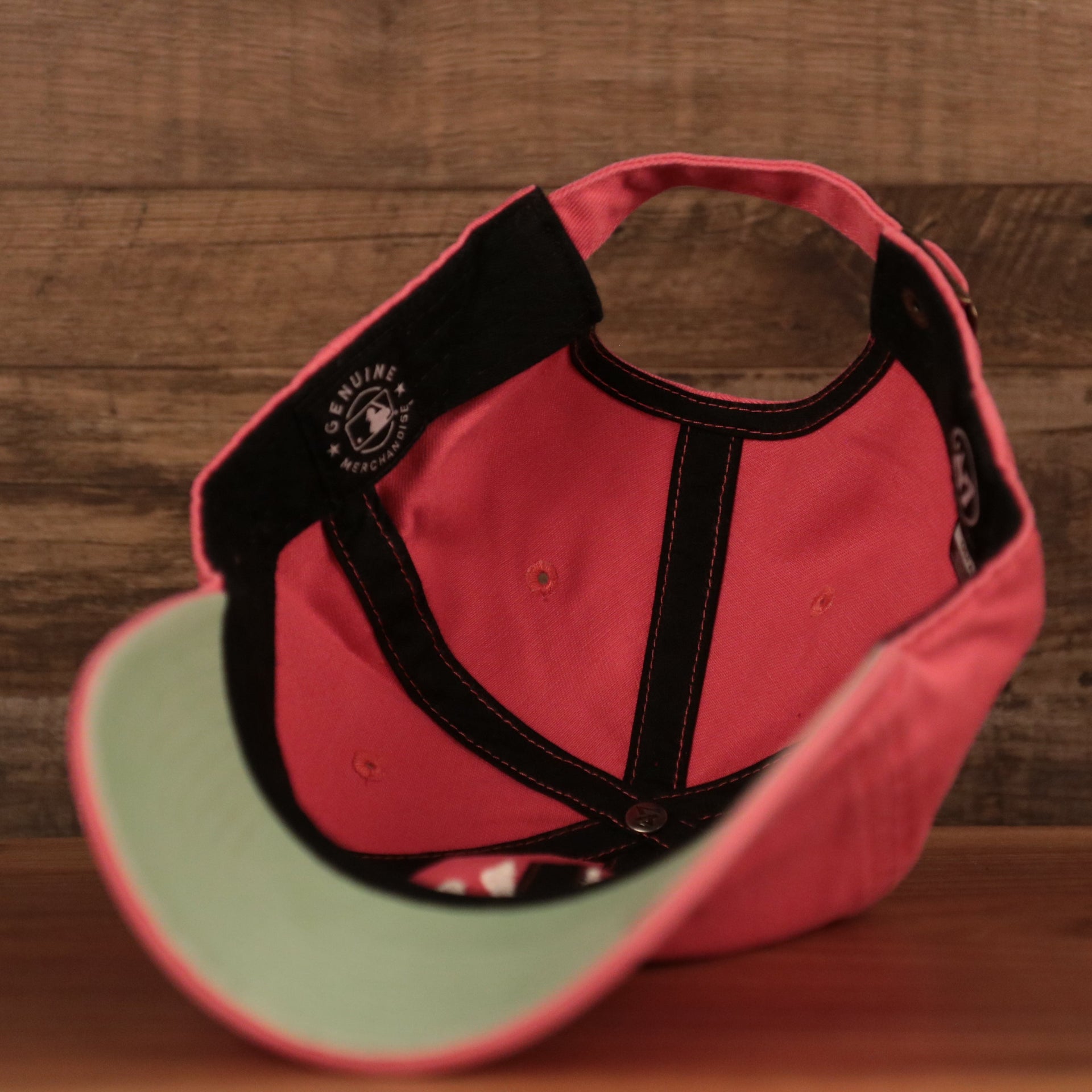 An inside look of the pink New York Yankees green brim bottom adjustable cap.