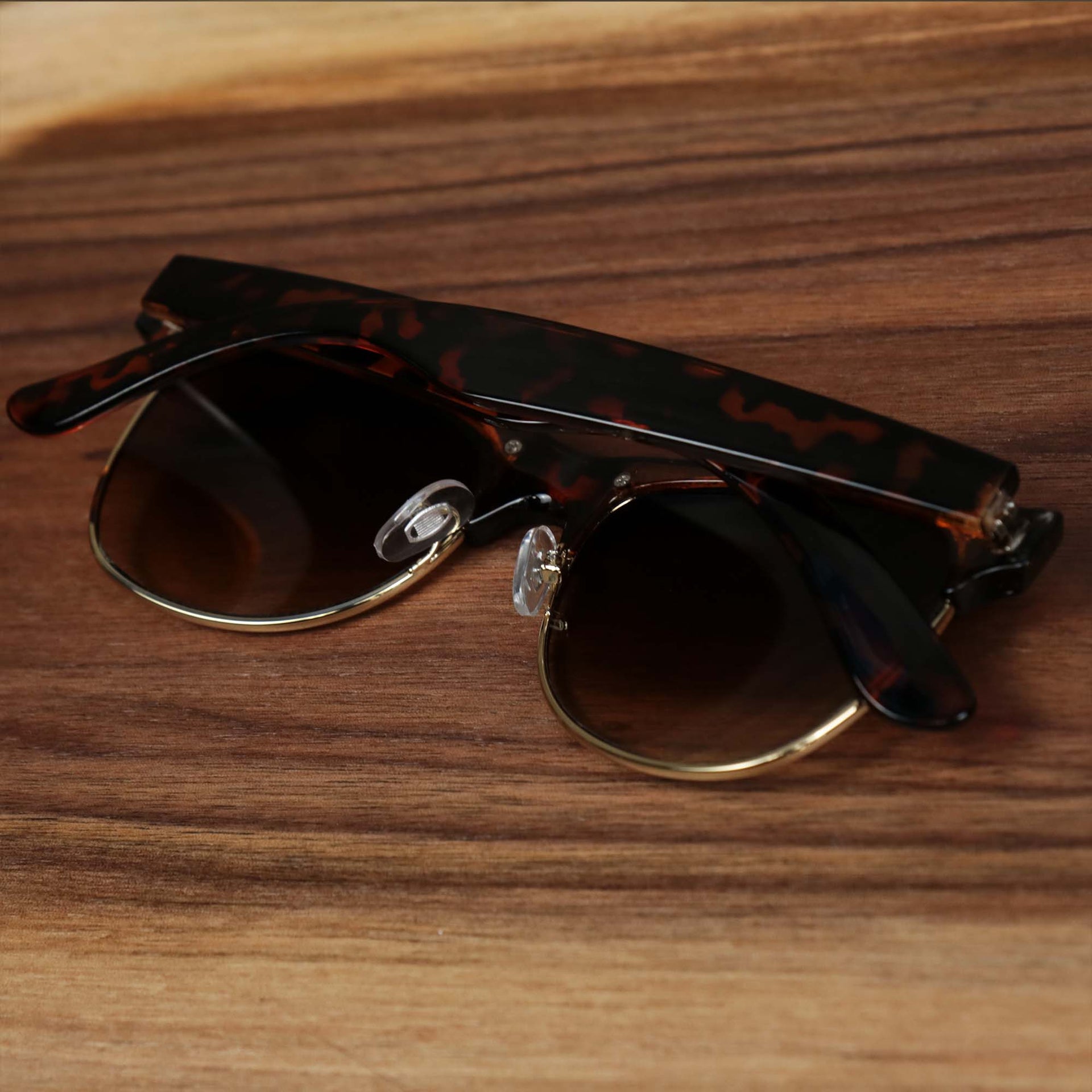 The Thick Top and Metal Bottom Frame Brown Lens Sunglasses with Tortoise Frame folded up