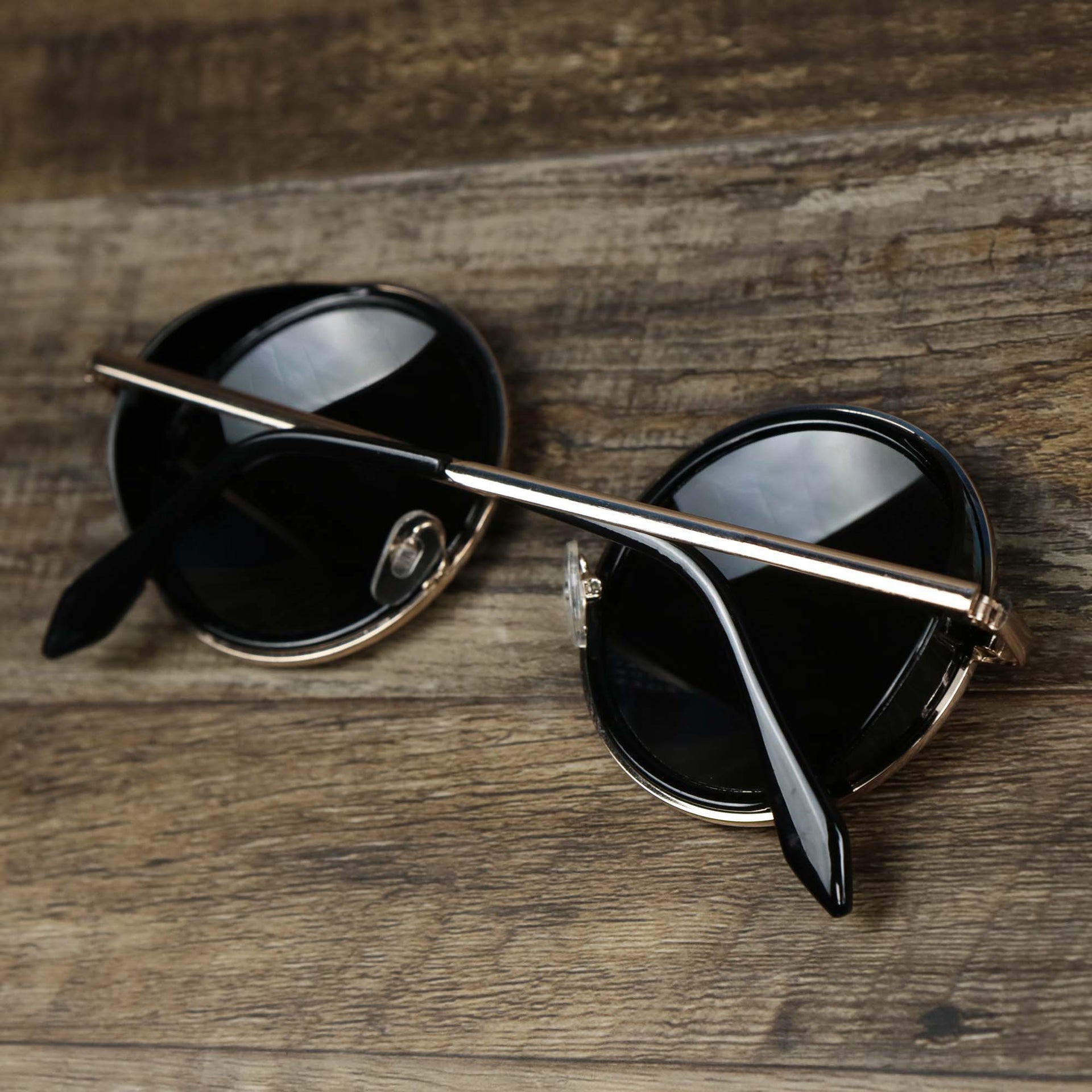 The Circle Frame Black Lens Sunglasses with Gold Frame folded up
