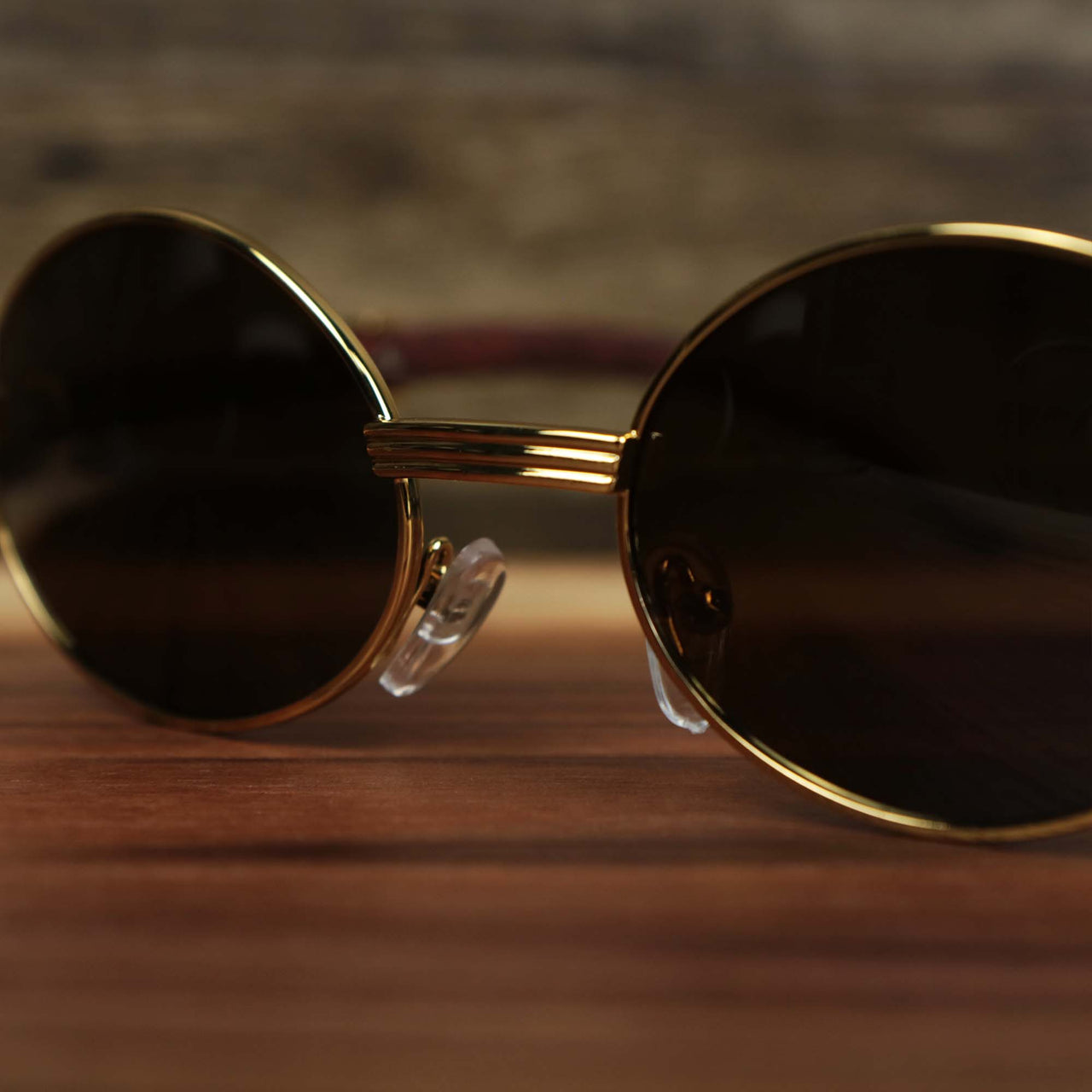 A close up of the Oval 3 Row Frame Brown Lens Sunglasses with Gold Frame