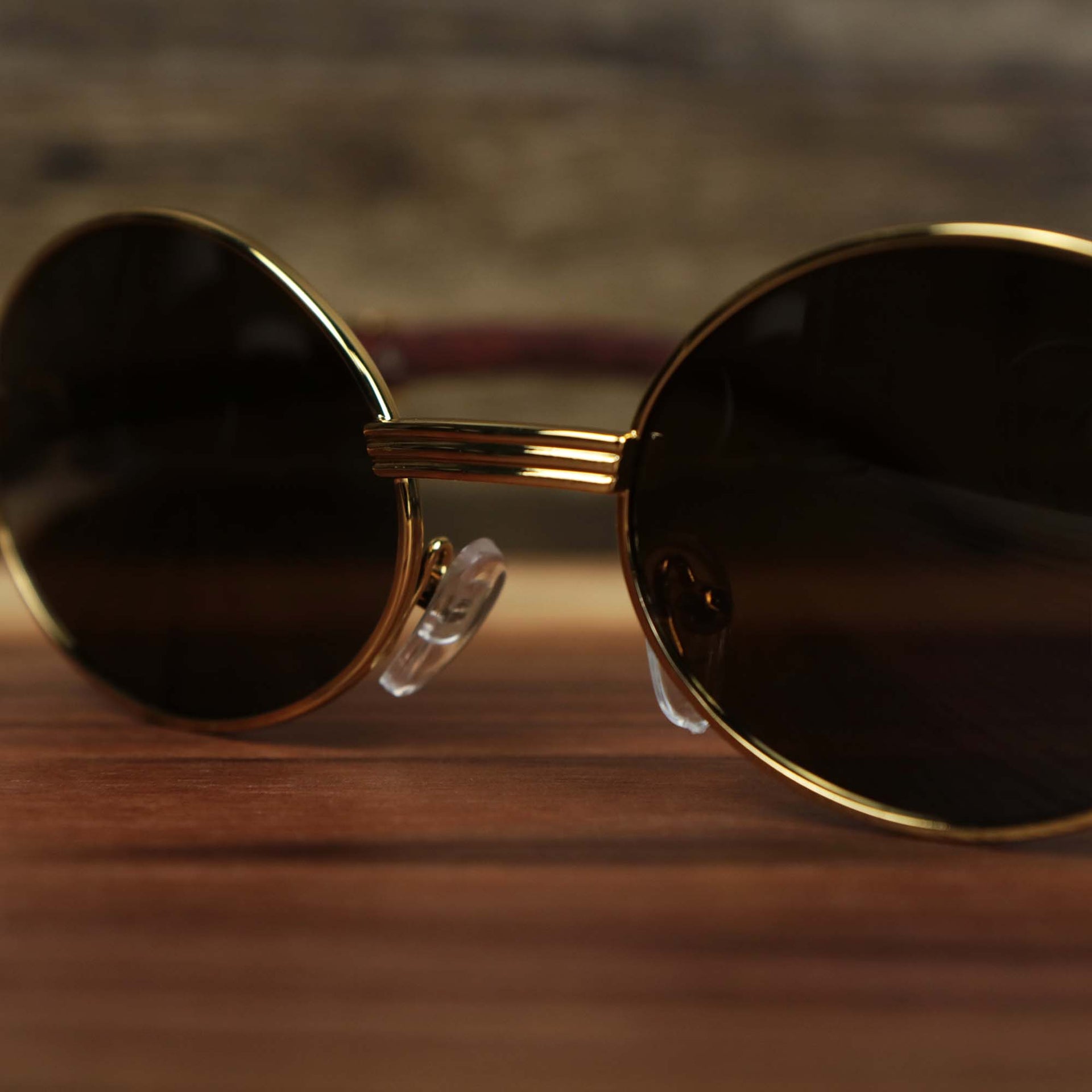 A close up of the Oval 3 Row Frame Brown Lens Sunglasses with Gold Frame