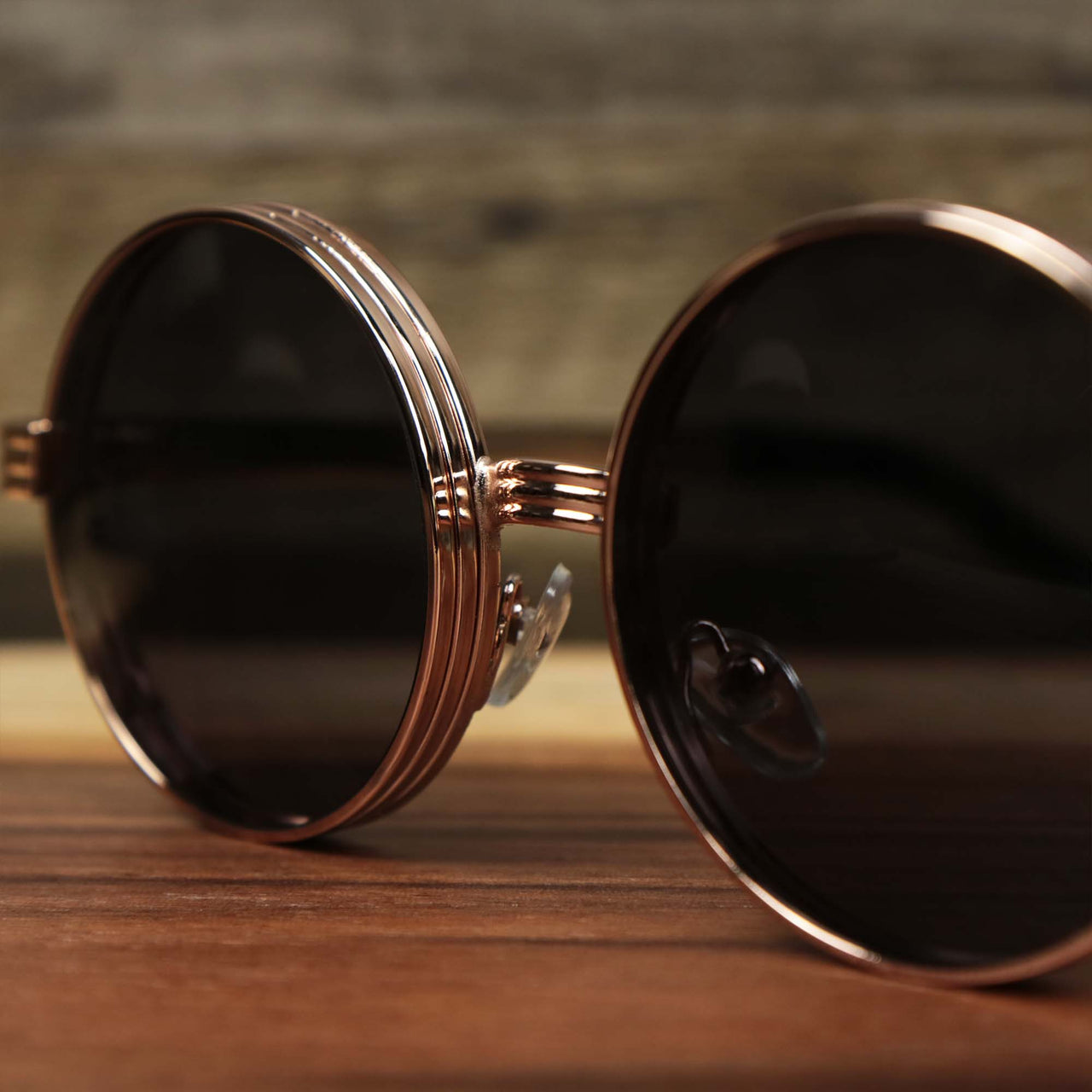 The bridge on the Round 3 Row Frame Black Lens Sunglasses with Rose Gold Frame