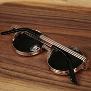 The Round 3 Row Frame Black Lens Sunglasses with Rose Gold Frame folded up