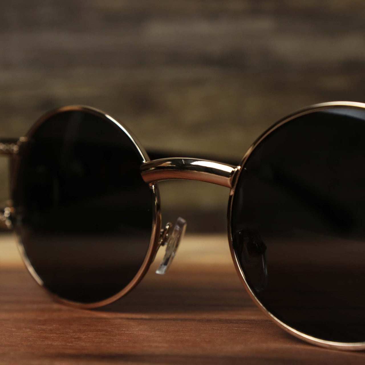 A close up of the bridge on the Circle Frame Lion Head Emblem Black Lens Sunglasses with Rose Gold Frame