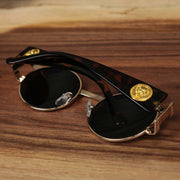 The Circle Frame Lion Head Emblem Black Lens Sunglasses with Rose Gold Frame folded up