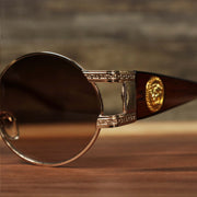 A close up of the hinge on the Circle Frame Lion Head Emblem Brown Lens Sunglasses with Rose Gold Frame