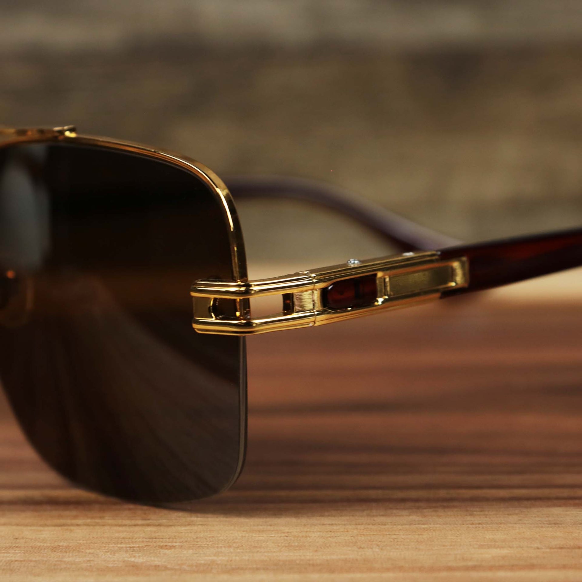 The hinge on the Round Rectangle Frame Brown Lens Sunglasses with Gold Frame