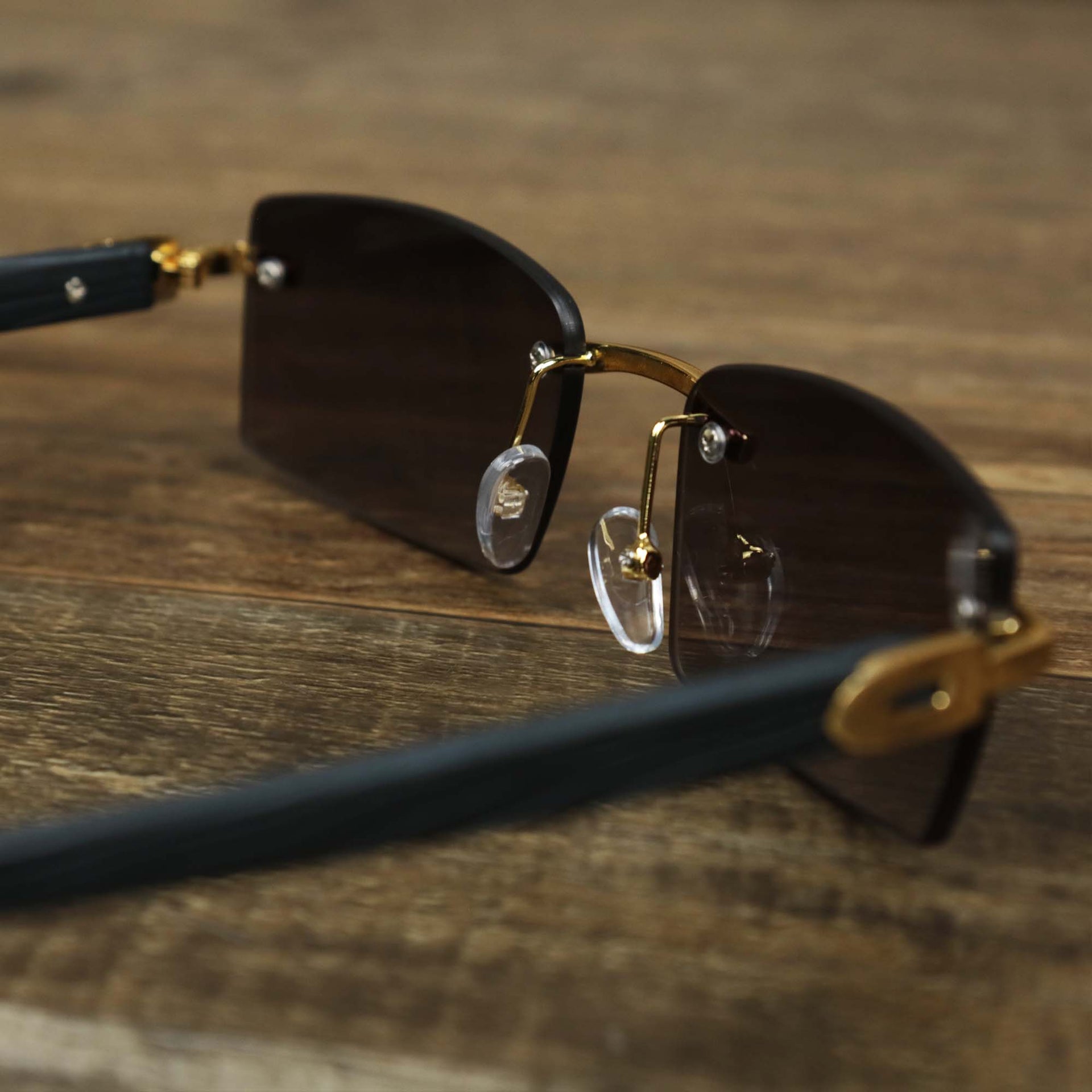 The inside of the Rectangle Wood and Metal Frame Black Lens Sunglasses with Gold Frame