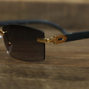 The hinge on the Rectangle Wood and Metal Frame Black Lens Sunglasses with Gold Frame