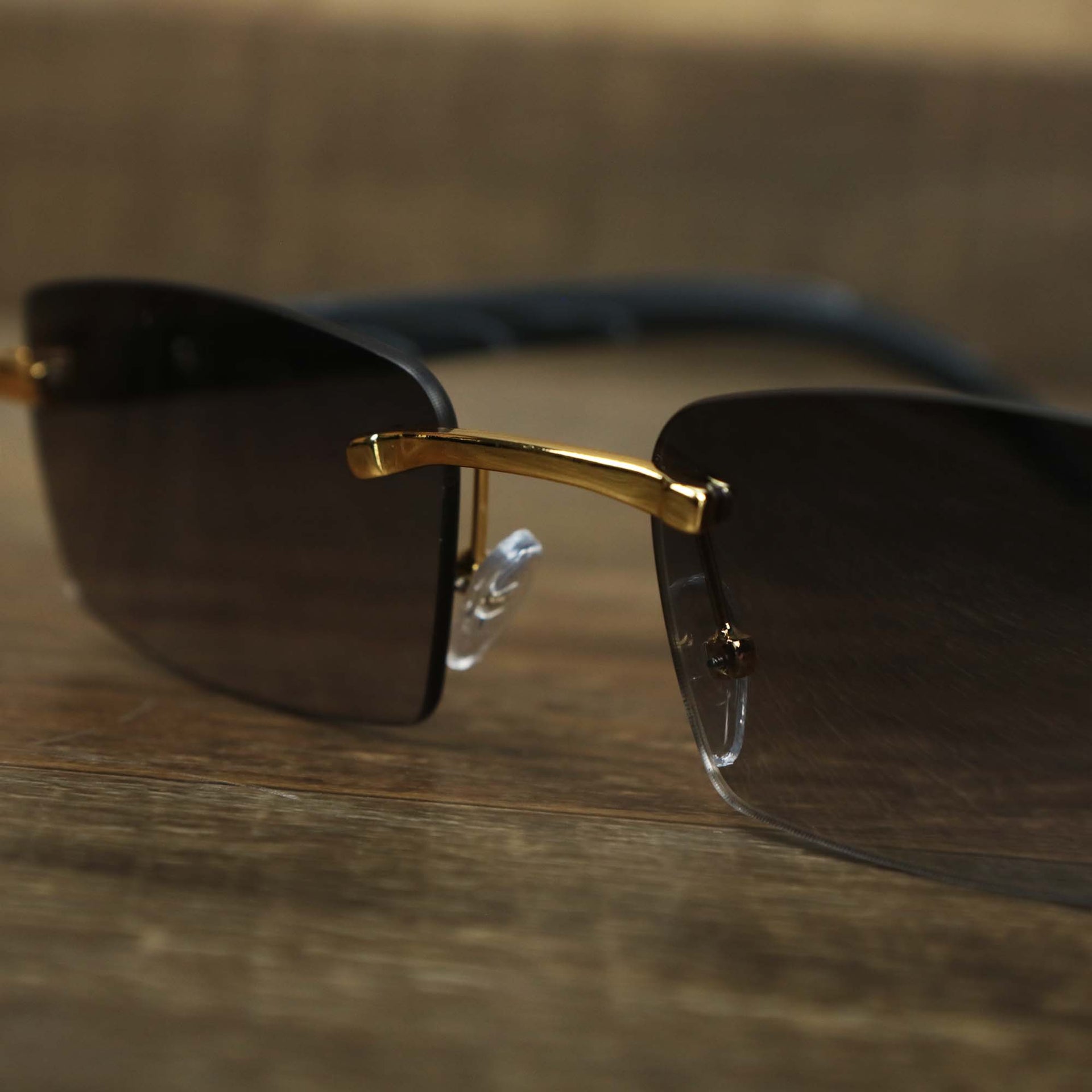 The bridge of the Rectangle Wood and Metal Frame Black Lens Sunglasses with Gold Frame