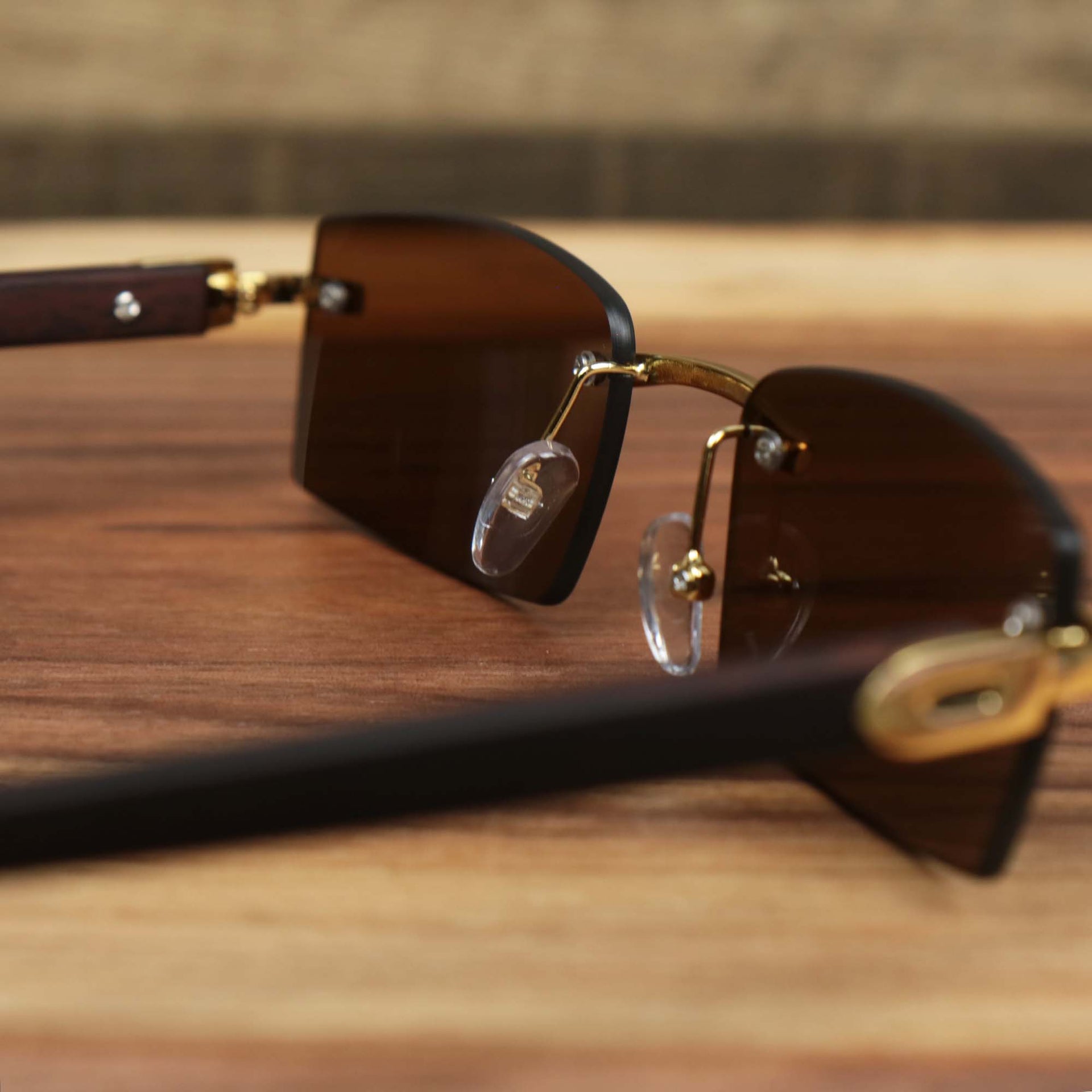 The inside of the Rectangle Wood and Metal Frame Brown Lens Sunglasses with Gold Frame
