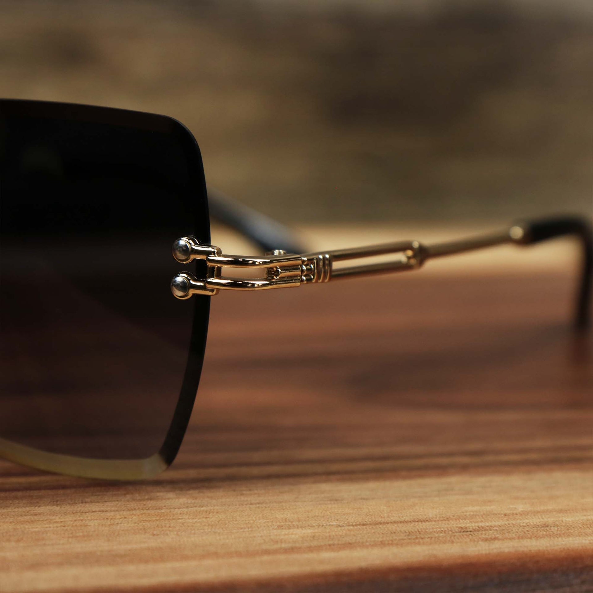 A close up of the hinge on the Large Lightweight Frame Brown Lens Sunglasses with Gold Frame