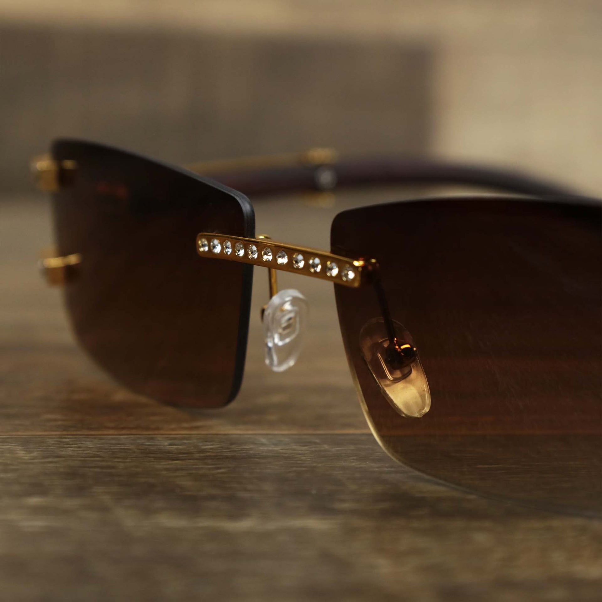 The bridge of the Rectangle Frames Brown Gradient Lens Flooded Sunglasses with Gold Frame