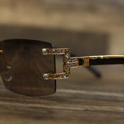 The hinge on the Rectangle Frames Brown Lens Flooded Sunglasses with Gold Frame