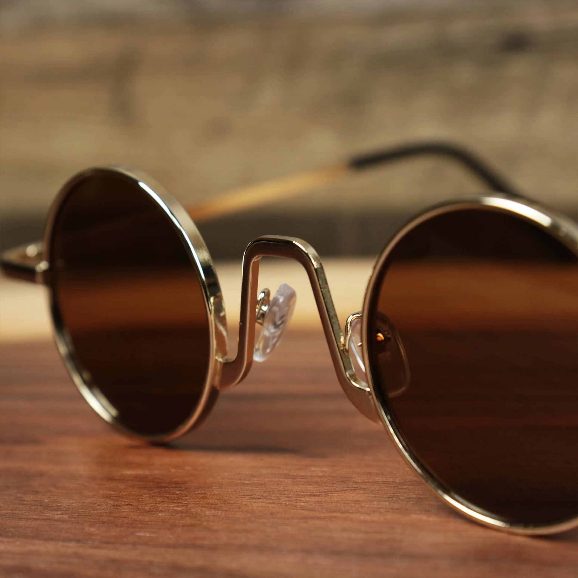 The bridge on the Round Frames Brown Lens Sunglasses with Gold Frame