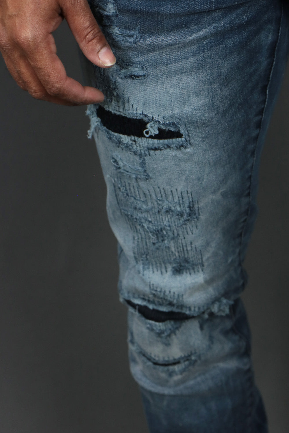 A close up of the ripped leggings on the Deep Blue Distressed Denim Pants | Jordan Craig