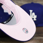 The undervisor on the Los Angeles Dodgers Pop Sweat Pastel World Series Side Patch Fitted Cap With Pink Undervisor | Royal Blue 59Fifty Cap