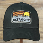 The front of the Youth New Jersey Ocean City Sunset Mesh Back Trucker Hat | Black And Black Mesh Youth Trucker Hat