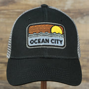The front of the Youth New Jersey Ocean City Sunset Mesh Back Trucker Hat | Black And Grey Mesh Youth Trucker Hat