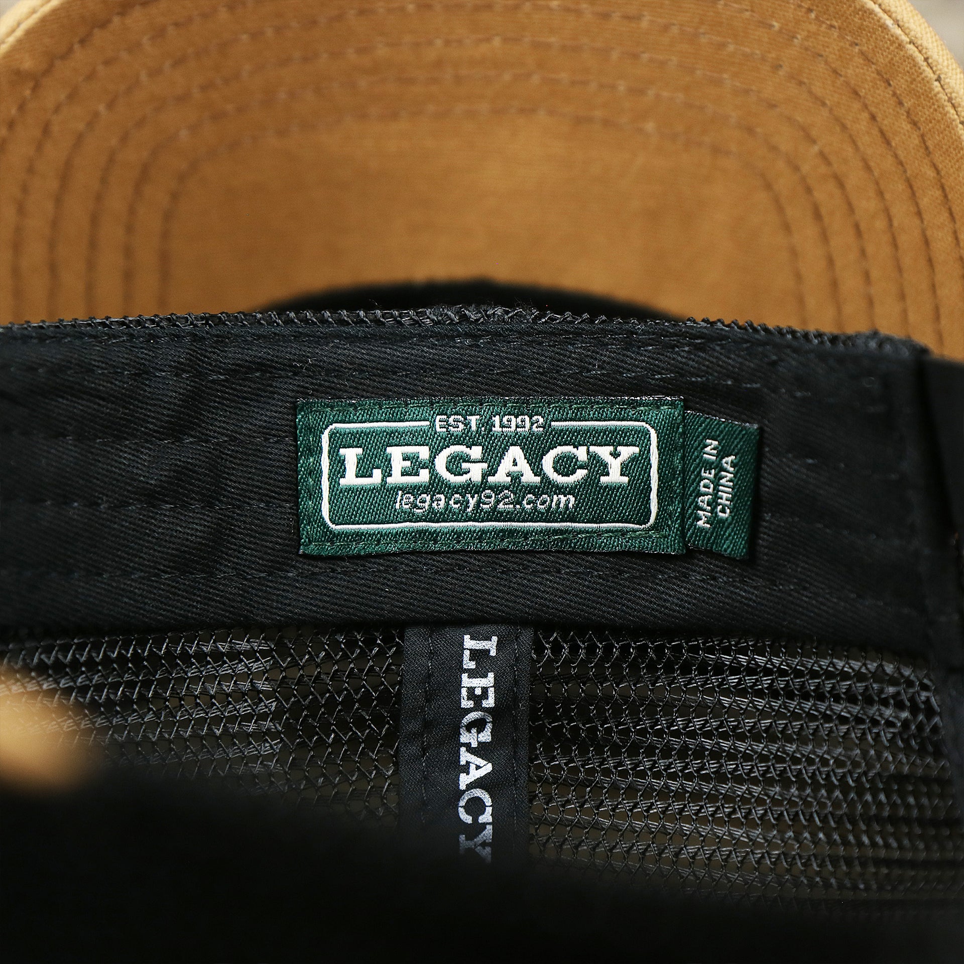 The Legacy Tag on the Youth New Jersey Ocean City Sunset Mesh Back Trucker Hat | Gray And Black Mesh Youth Trucker Hat