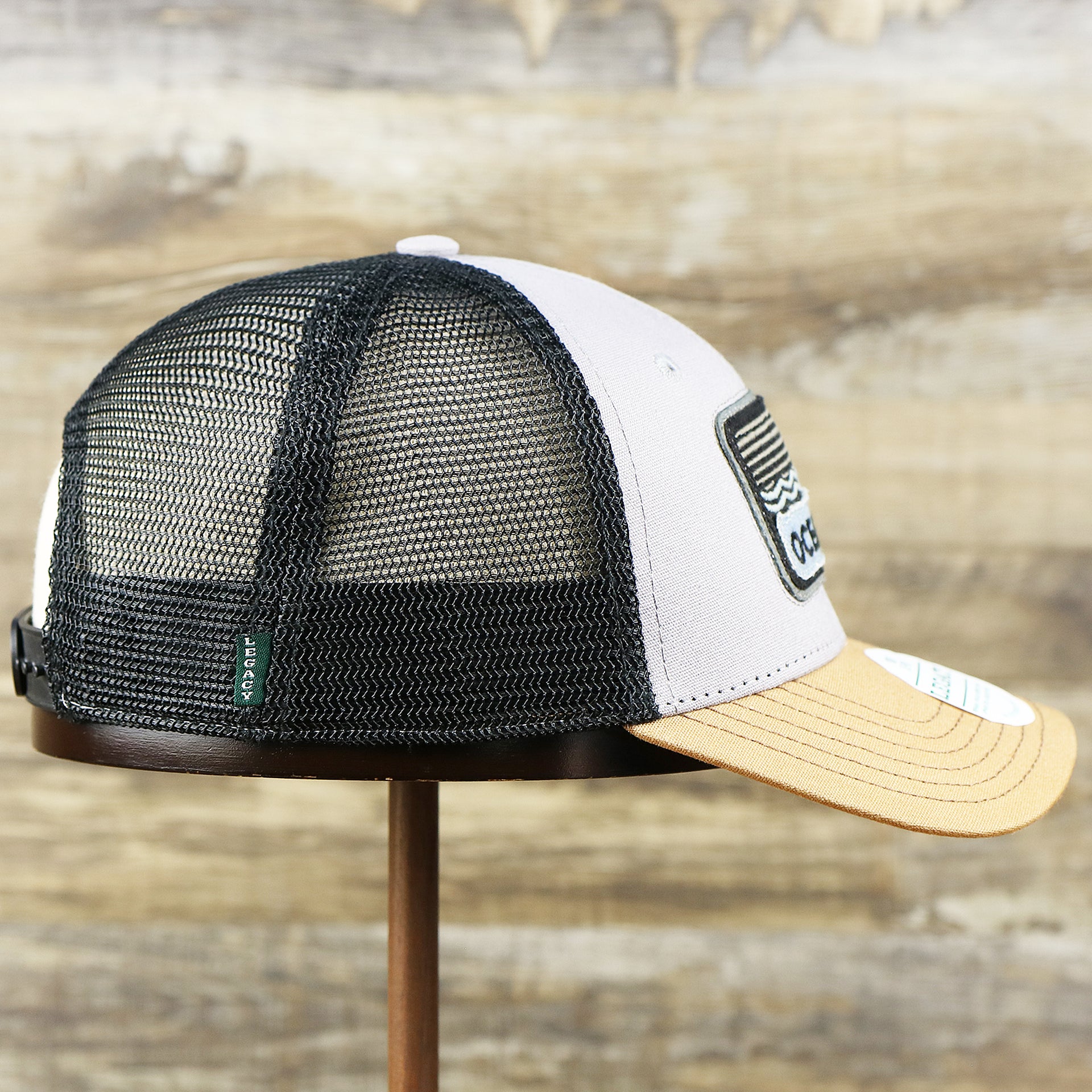 The wearer's right on the Youth New Jersey Ocean City Sunset Mesh Back Trucker Hat | Gray And Black Mesh Youth Trucker Hat