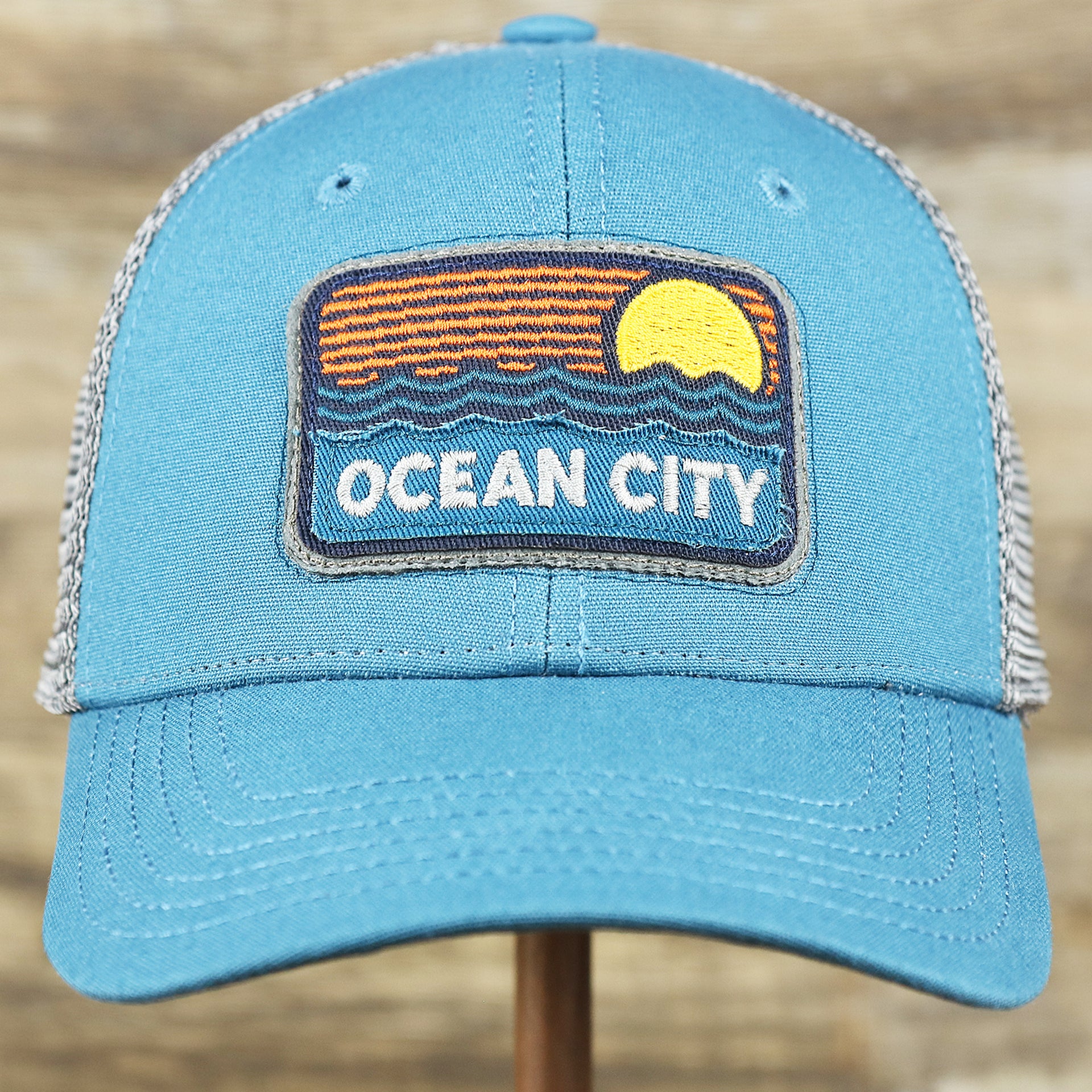 The front of the Youth New Jersey Ocean City Sunset Mesh Back Trucker Hat | Marine Blue And Dark Gray Mesh Youth Trucker Hat