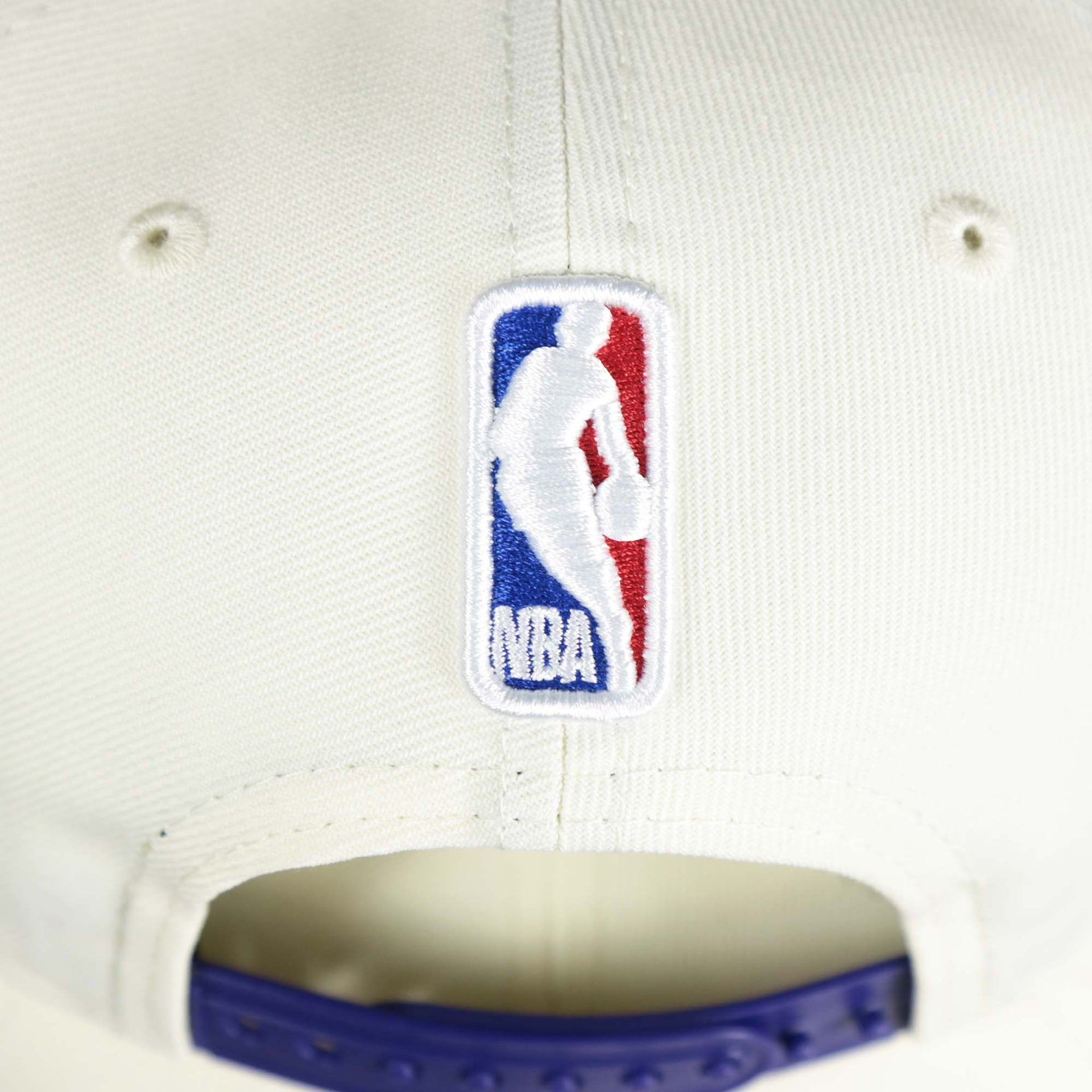 The NBA Jerry West Logo on the back of the Youth Los Angeles Lakers NBA 2022 Draft Gray Bottom 9Fifty Snapback | New Era Cream/Purple