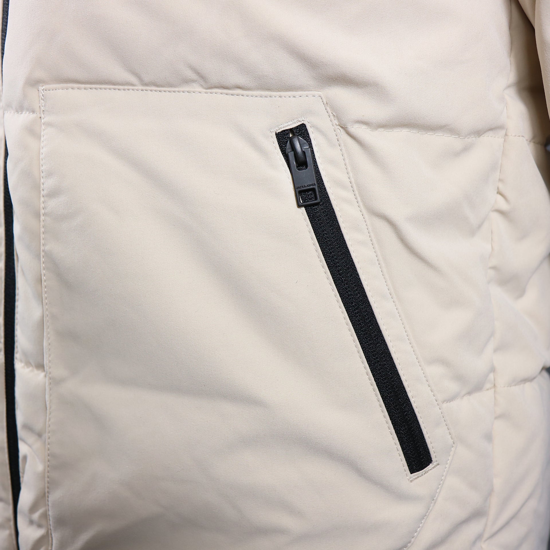 The waist pocket on the Jack And Jones Moonbeam Puffer Jacket With Hidden Pocket | Cream Puffer Jacket