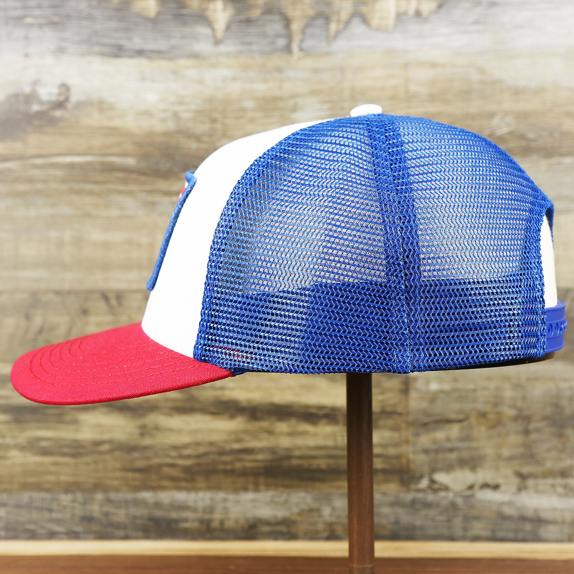 The wearer's left on the Ocean City Stars And Stripes USA Flag Royal Blue Mesh Trucker Hat | White And Royal Blue Trucker Hat