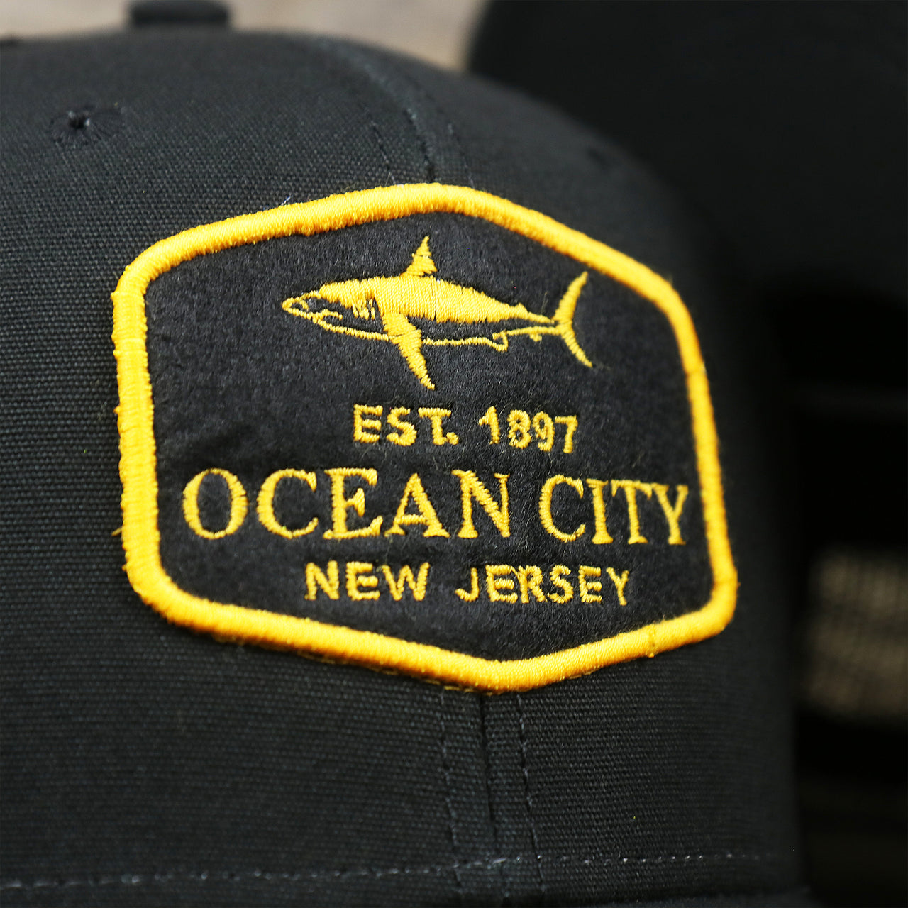 The Ocean City Shark Patch on the Ocean City New Jersey Shark Patch Mesh Back Trucker Hat | Black Mesh Snapback