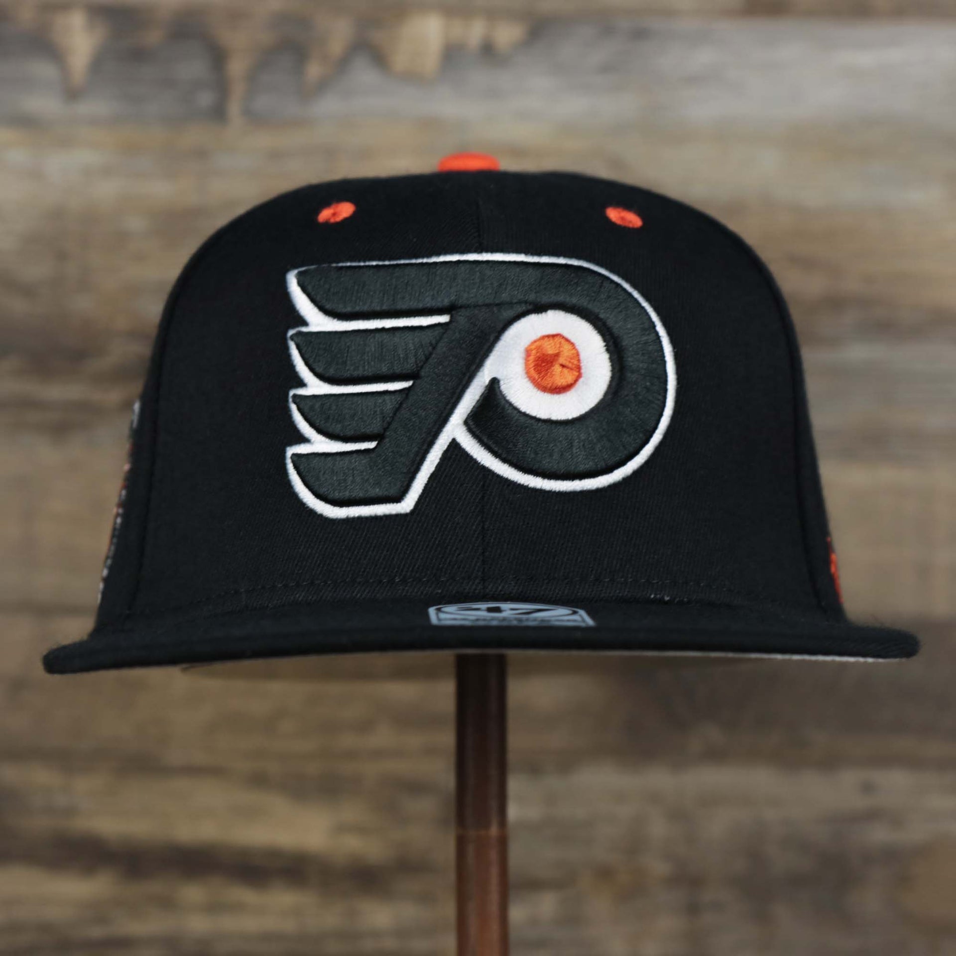 The front of the Philadelphia Flyers Side Patch Dugout Side Defender Fitted Cap | Black Stretch Fitted Cap