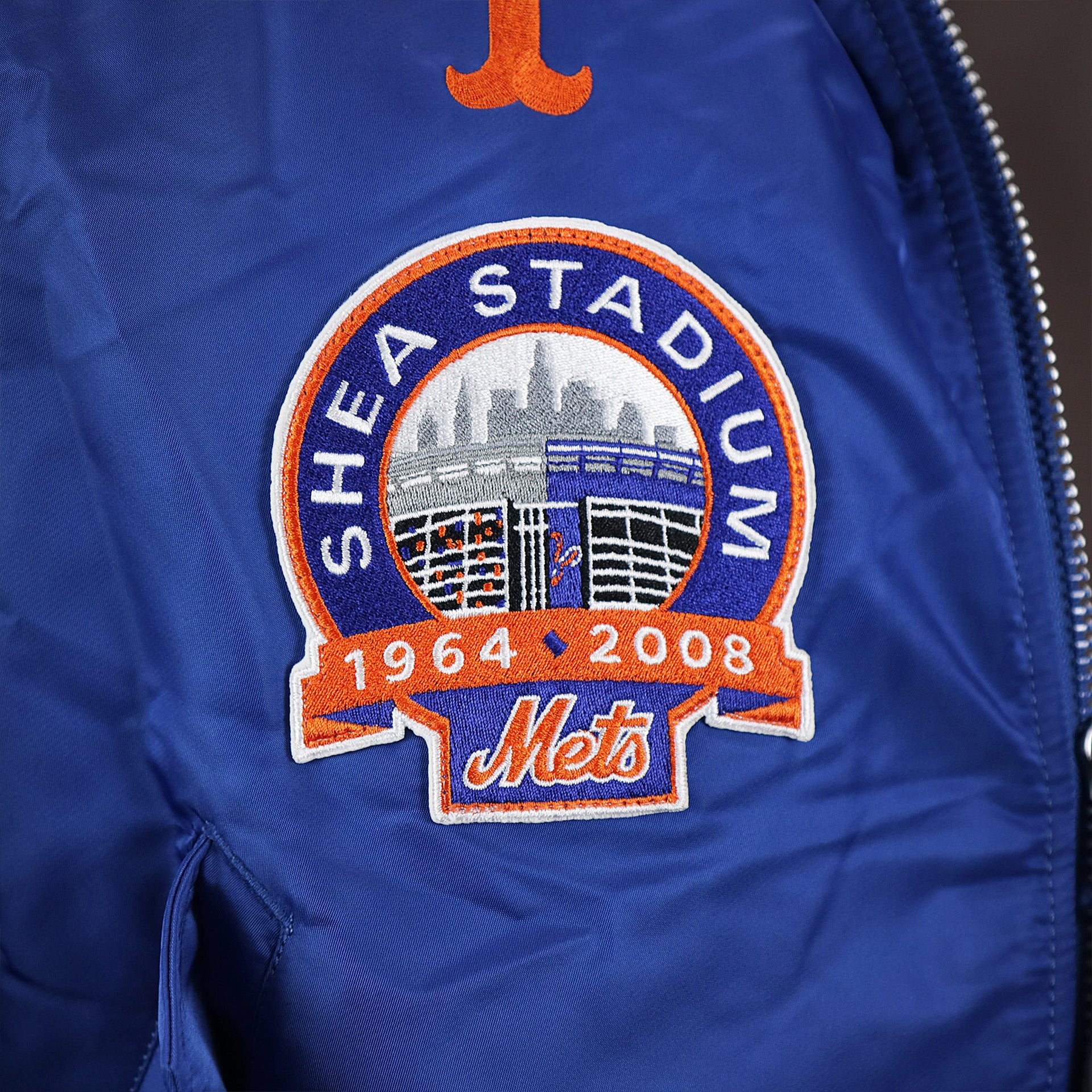 The Shea Stadium Logo on the New York Mets MLB Patch Alpha Industries Reversible Bomber Jacket With Camo Liner | Royal Blue Bomber Jacket