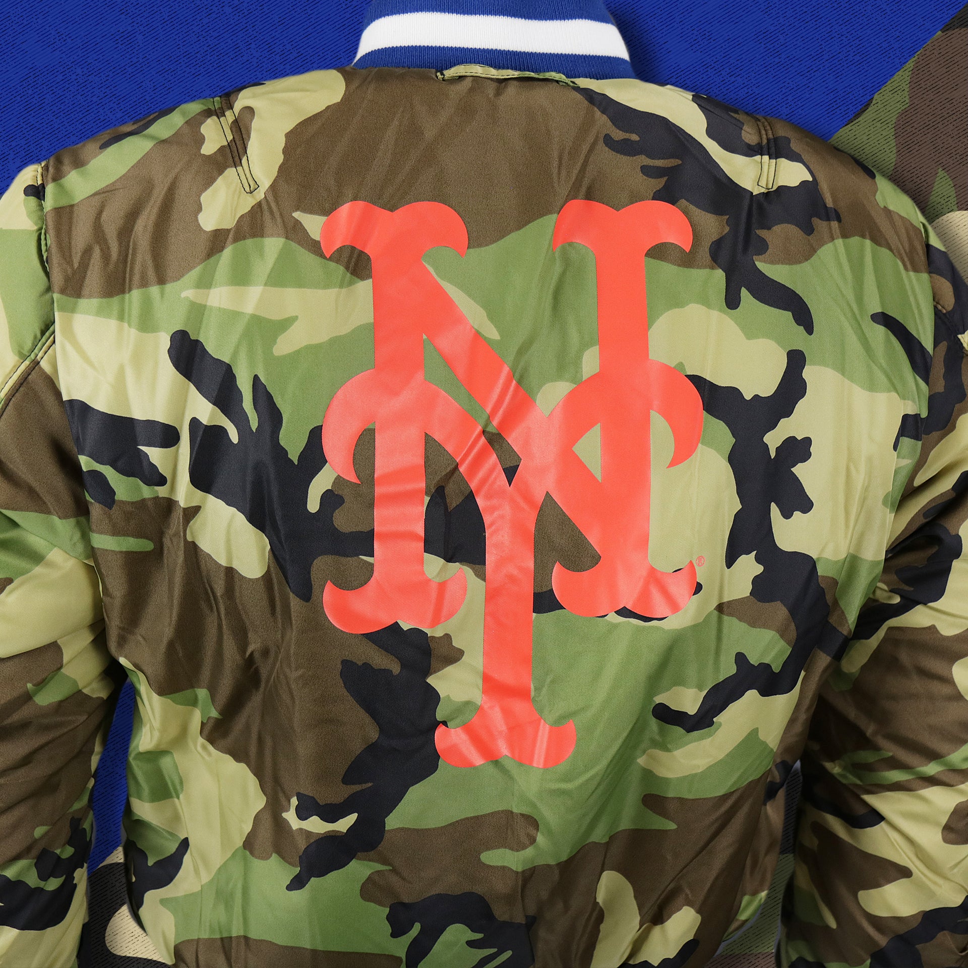 The New York Mets Logo Printed in Orange on the New York Mets MLB Patch Alpha Industries Reversible Bomber Jacket With Camo Liner | Royal Blue Bomber Jacket