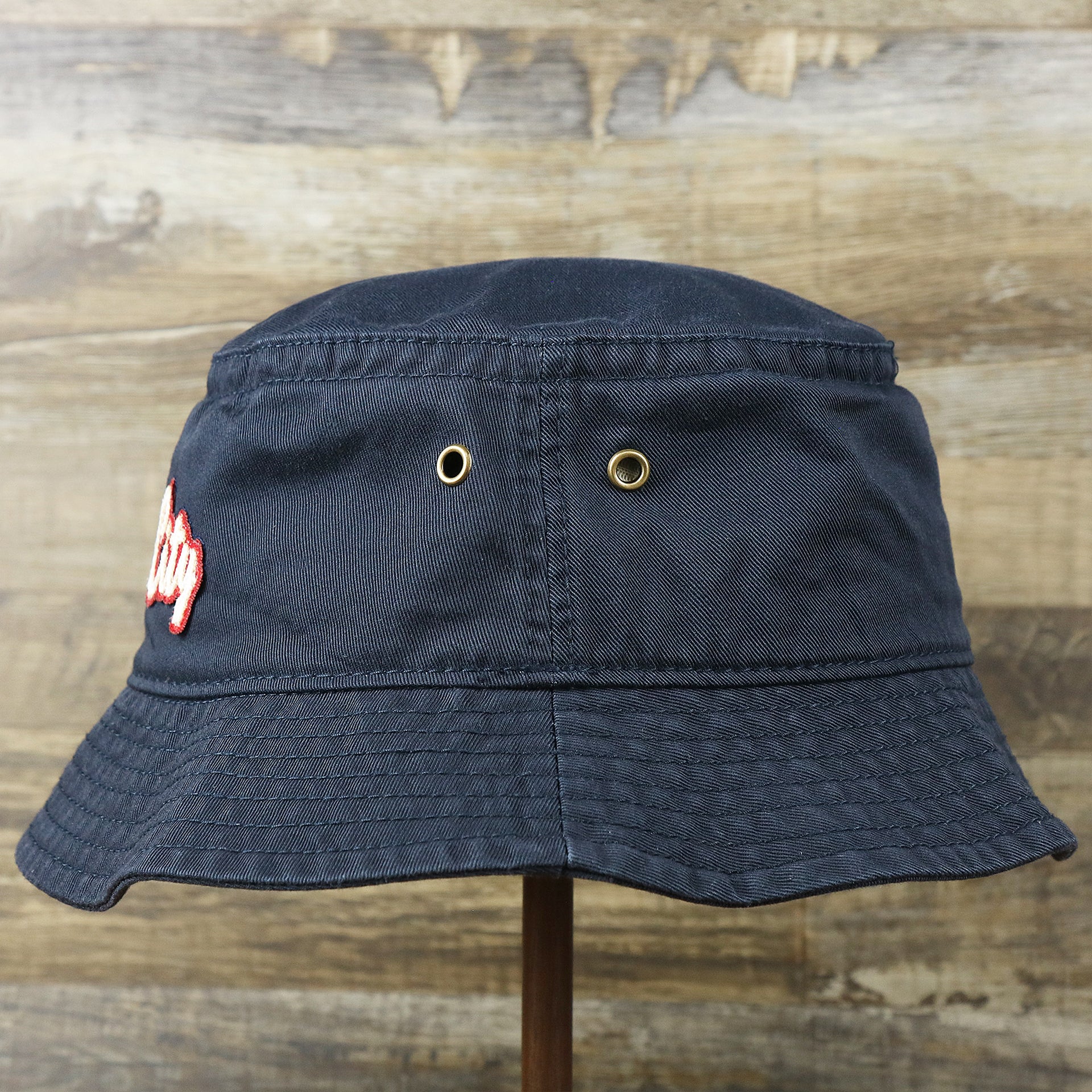 The wearer's left on the White OCNJ Double Wordmark Red Outline Bucket Hat | Navy Bucket Hat