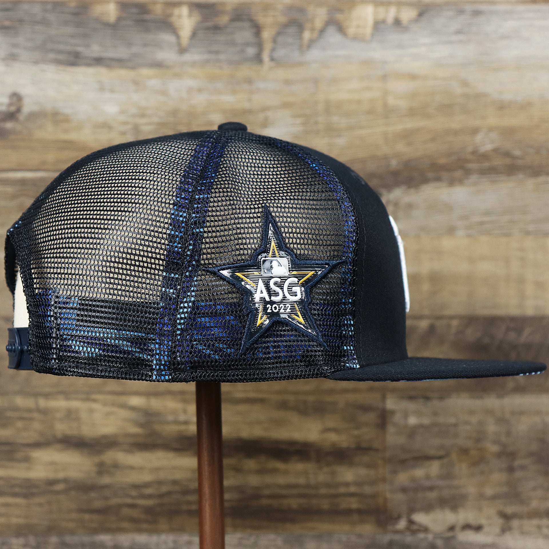 The wearer's right on the New York Yankees Metallic All Star Game MLB 2022 Side Patch 9Fifty Mesh Snapback | ASG 2022 Navy Blue Trucker Hat