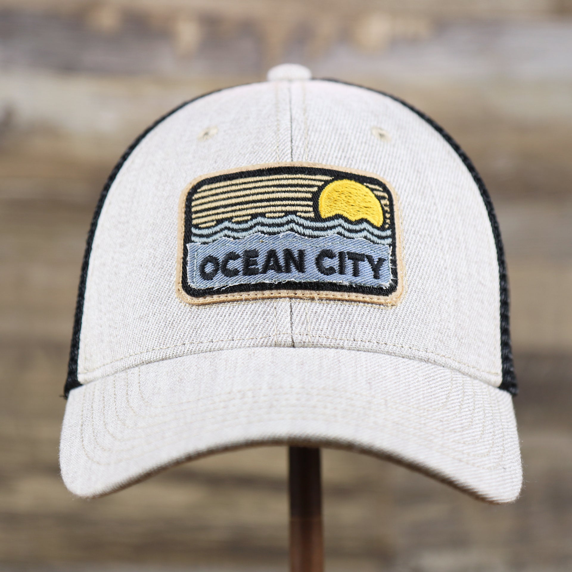 The front of the New Jersey Ocean City Sunset Mesh Back Trucker Hat | Heather Tan And Black Mesh Trucker Hat